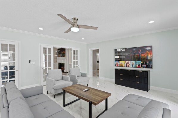 A modern living room with a sofa set, a coffee table, and a TV mounted on the wall.