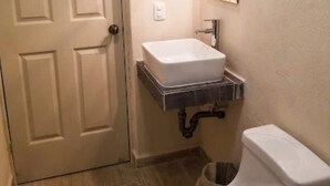 A small bathroom with a white toilet, a white sink, and a mirror above the sink. - Hotel Vías Maya Bacalar - Free Bikes (Bacalar)