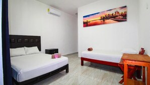 A hotel room with a bed, bedside table, nightstand, and a painting on the wall. - Hotel Vías Maya Bacalar - Free Bikes (Bacalar)