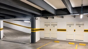Un parking avec des planchers en béton, des lignes jaunes et des casiers numérotés de 085 à 088.