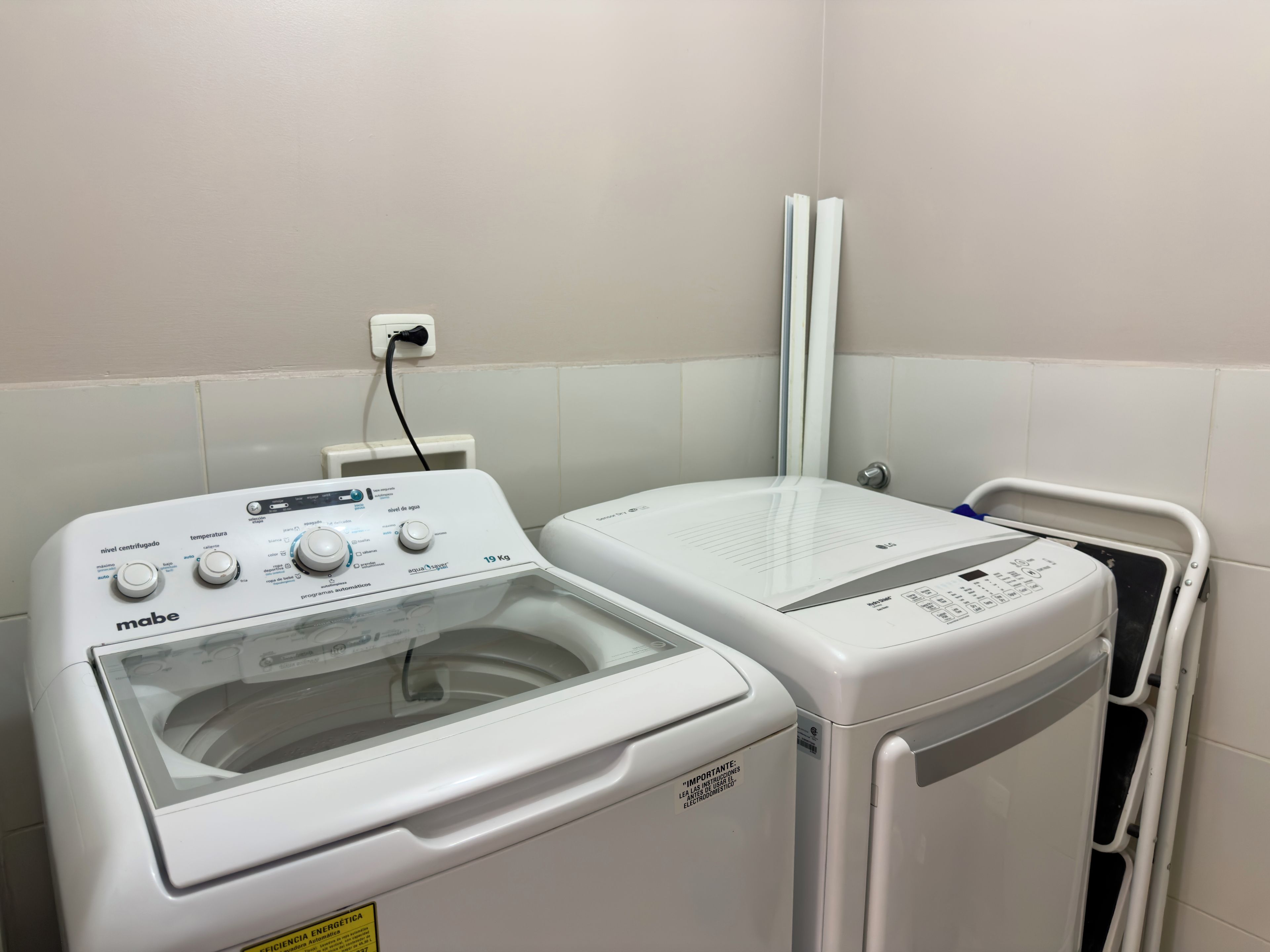 A front-loading washing machine and a dryer side by side in a laundry room.