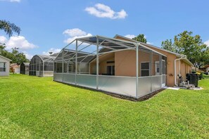 A house with a large glass greenhouse attached to the side.