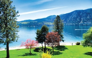 A lake with a bench and trees in the foreground, surrounded by mountains. - Manson 3BR Lake Chelan View (Manson)