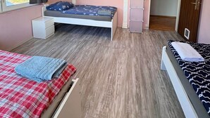 A bedroom with a bed, a window, a wardrobe, and a door. - Spacious lodging near the industrial park (5 beds) (Bielefeld)