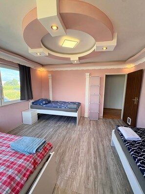 A bedroom with a bed, a window, a wardrobe, and a door.