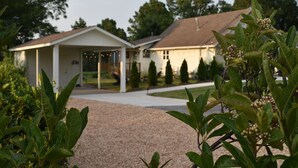 A two-story house with a covered porch and a gravel driveway. - La Ferme - french for country farmhouse 3BR/1BA in Rogers. (Rogers)