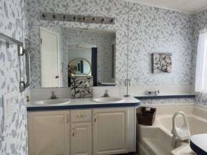A bathroom with two sinks, a large mirror, and a bathtub. - Vibrant Active Adult 55+ community w/clubhouse, pool w/hot tub, fitness room. (Parrish)