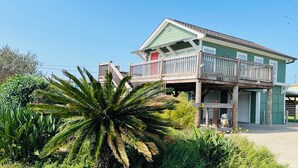Une maison à deux étages avec un balcon, un garage et le numéro « 101 » sur le côté.