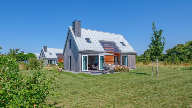 A modern house with a sloped roof, a large open porch, and a well-maintained lawn. - Stunning home in Kamperland with WiFi (Kamperland)