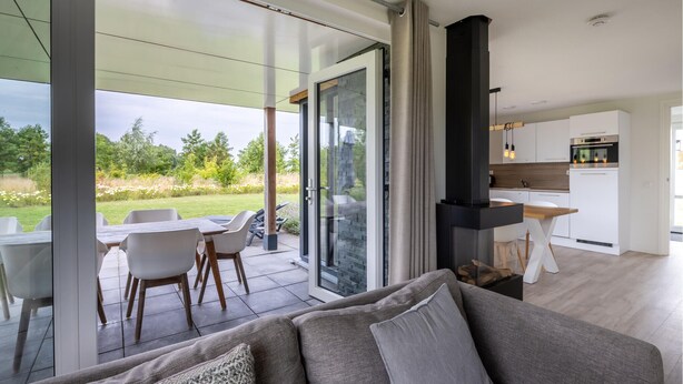 A modern living space with a sofa, dining area, and kitchen. - 3 bedroom awesome home in Kamperland (Kamperland)