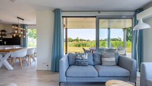 A modern living room with a sofa, coffee table, and dining area. - Amazing home in Kamperland with WiFi (Kamperland)