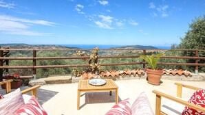 A terrace with a wooden table and chairs, a view of the countryside, and terracotta pots. - Nice home in Laureana Cilento (Laureana Cilento)