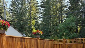 A wooden deck with a fire pit, outdoor seating, and a wooden fence. - Welcome to Cultus Lake’s “Aspen” at The Cedars (Cultus Lake)