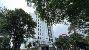 A multi-story building with a modern architectural design, featuring a prominent entrance with a glass facade. - Cozy Stay 1Br Apartment At 1 Cik Ditiro Residence (Jakarta)