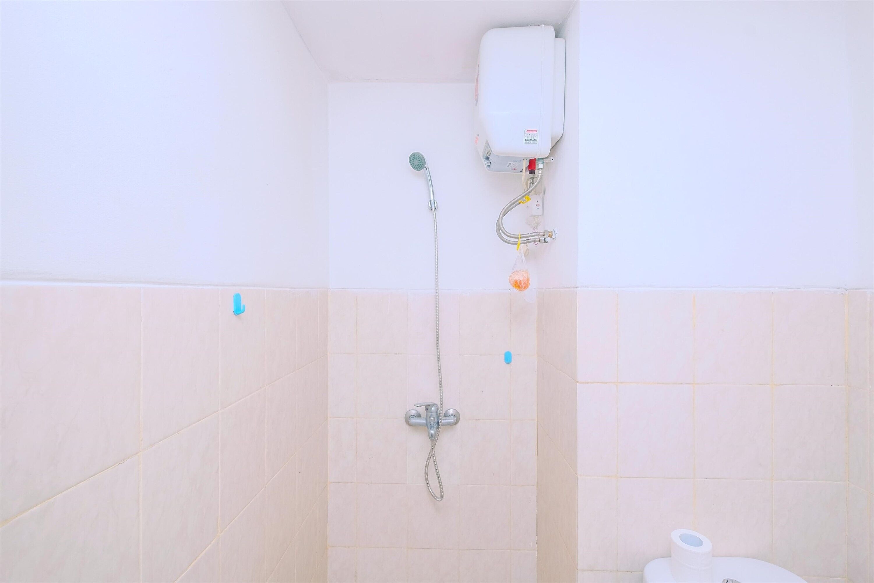 A bathroom with a shower, toilet, and a water heater.