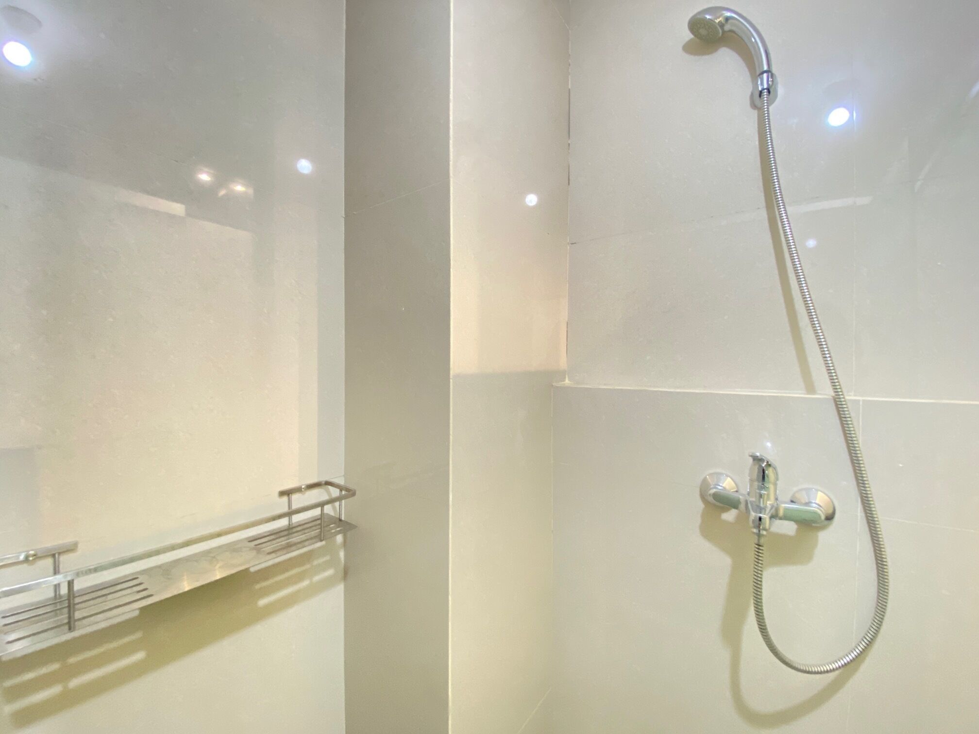 A bathroom with a shower, a mirror, and a towel rack.