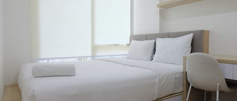 Ein modernes Schlafzimmer mit einem großen Bett, einem Schreibtisch und einem Stuhl.