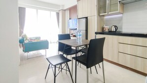 A modern kitchen with wooden cabinets, a black countertop, and a dining area with a table and chairs.