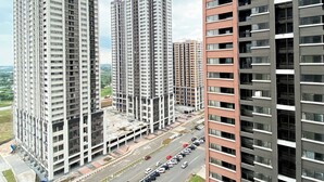 Un edificio residencial de gran altura con varios pisos, un estacionamiento al frente y una vista despejada del paisaje circundante.