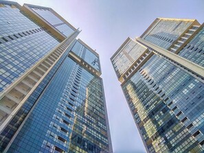 A view of tall, modern skyscrapers with reflective glass facades and a clear sky. - Spacious And Modern 3Br Ciputra World 2 Apartment (Jakarta)