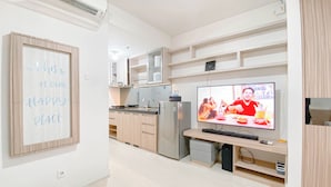 Eine moderne Küche mit integriertem Fernseher, Holzschränken und einer Kücheninsel.
