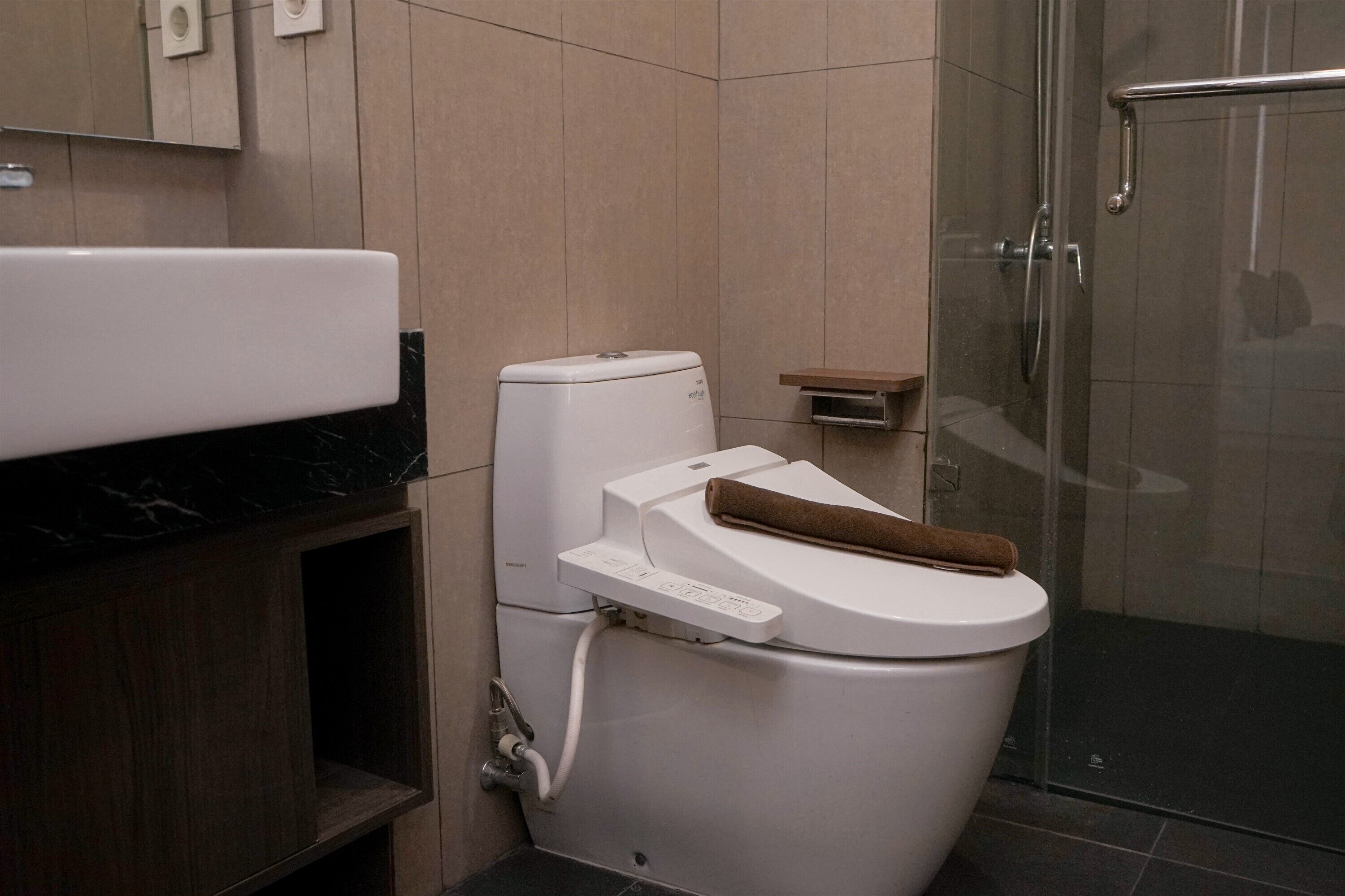 Un bagno moderno con servizi igienici, cabina doccia e un piano di lavoro in marmo.