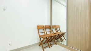 A room with two wooden chairs and a large mirror on the wall. - Spacious Studio Apartment B Residence (Pagedangan)