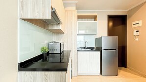 A modern kitchen with a built-in stove, a refrigerator, and a sink. - Comfort Living 2Br At Menteng Park Apartment (Jakarta)