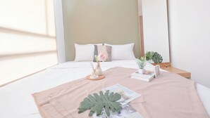 A neatly arranged hotel room with a bed, bedside table, and a window with natural light. - Good Location 2Br Apartment At Woodland Park Residence (Jakarta)