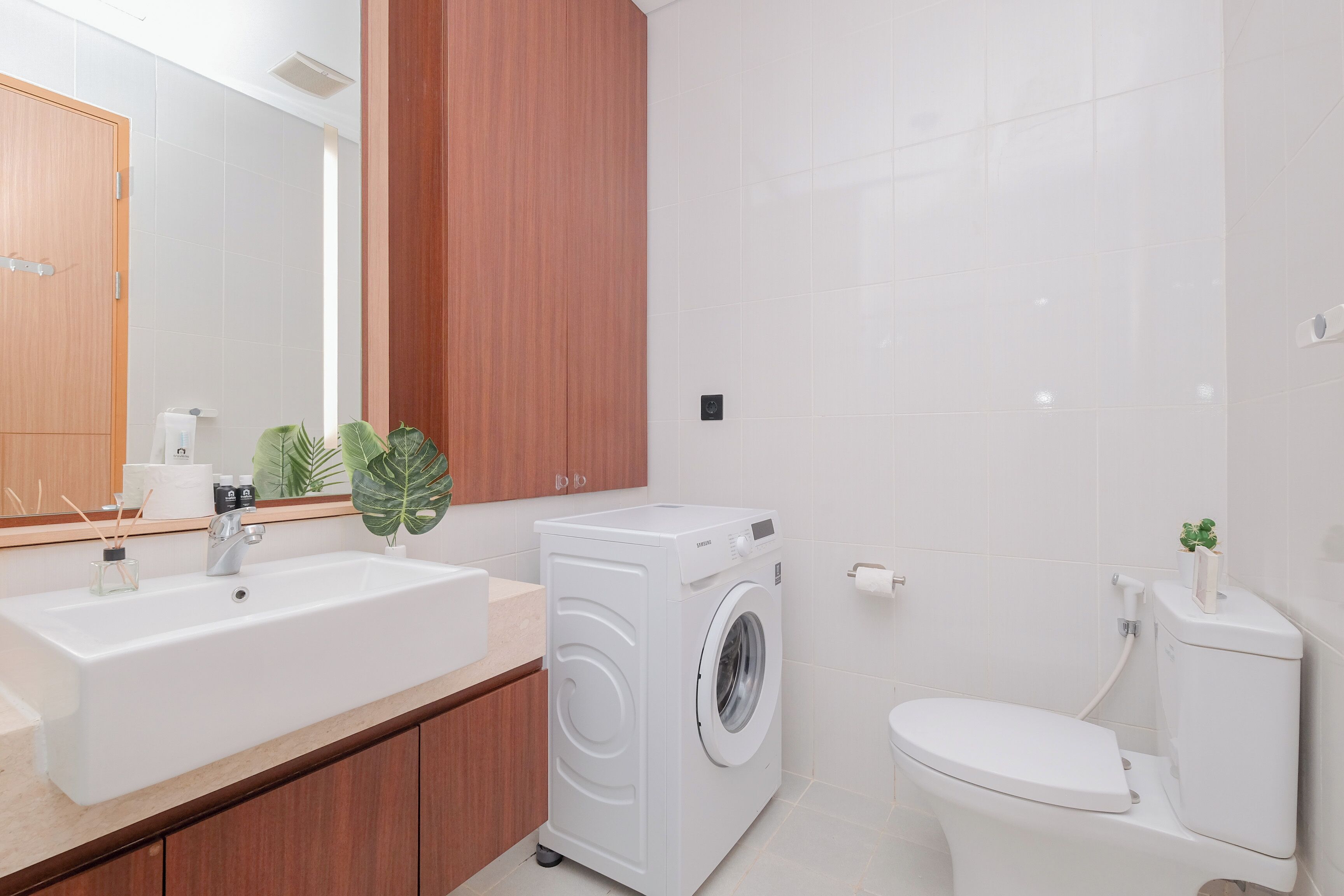 Une salle de bain moderne avec un grand lavabo, un lave-linge et des toilettes.