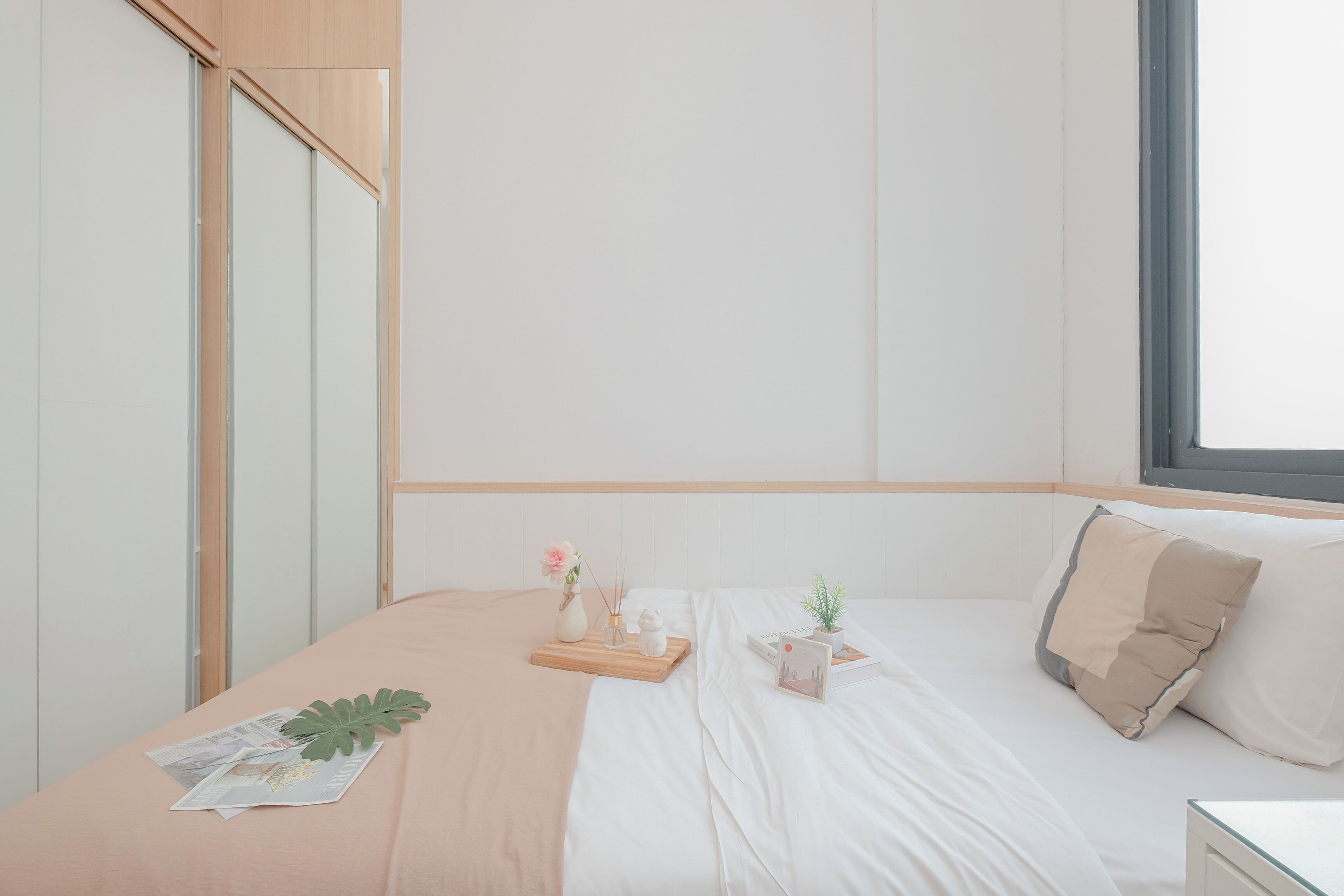Une chambre à coucher bien rangée, avec un lit, une table de chevet et une fenêtre.