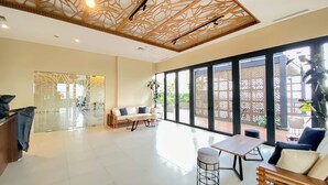 A spacious lobby with a modern design, featuring a wooden ceiling, large windows, and a seating area with a sofa and a table. - Modern Furnished 2Br At Samara Suites Apartment (Jakarta)