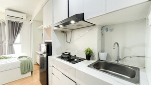 A modern kitchen with a stainless steel sink, a gas stove, and a black range hood.