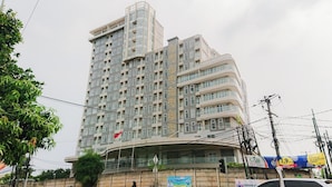 A multi-story building with a curved facade, balconies, and a flag.