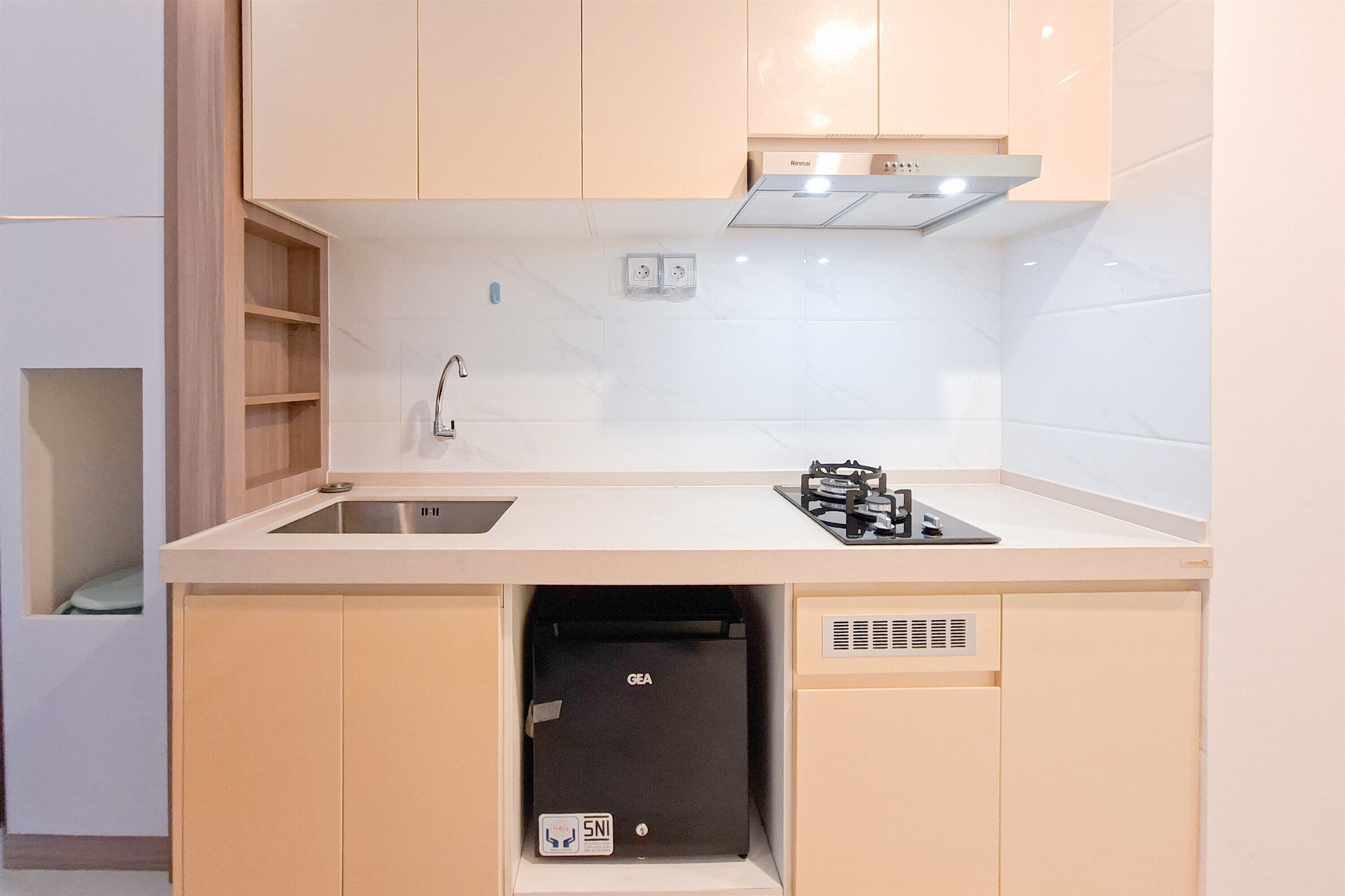 A compact kitchen with a sink, stove, and a built-in dishwasher.