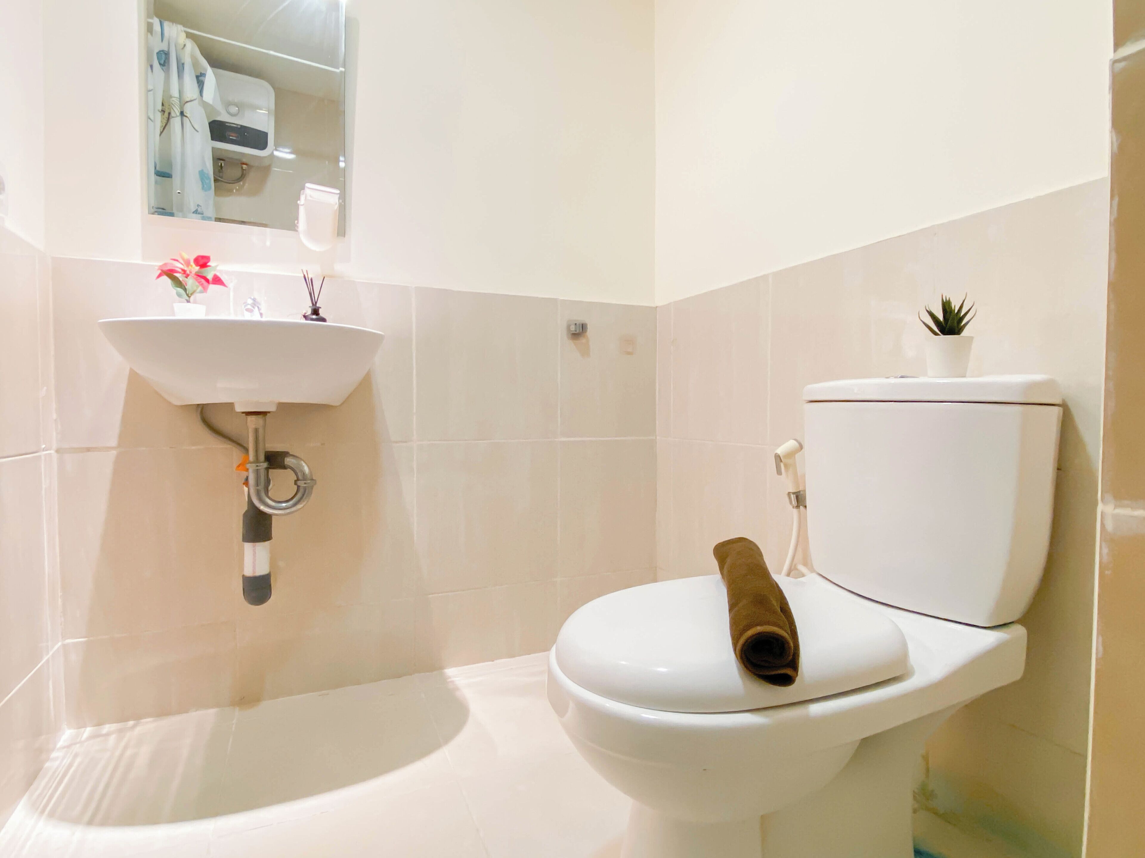 Une salle de bain avec un lavabo, des toilettes et une baignoire, le tout de couleur blanche.