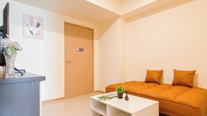 Ein modernes Wohnzimmer mit einem weißen Sofa, einem Couchtisch und einer Tür im Hintergrund.