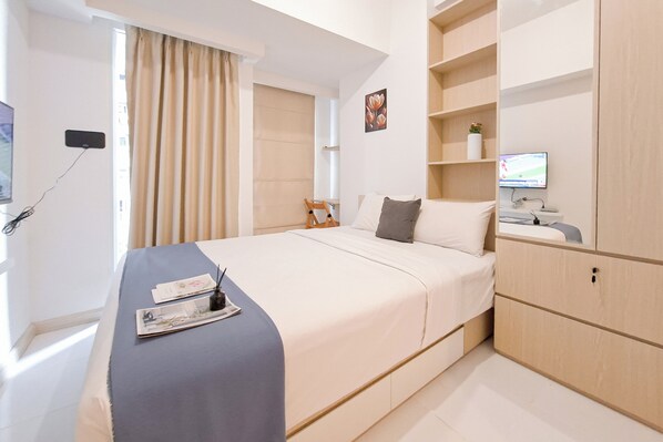 A modern hotel room with a large bed, a desk with a computer, and a TV. - Simple Style Studio Apartment (No Kitchen) At Tokyo Riverside Pik 2 (Teluknaga)