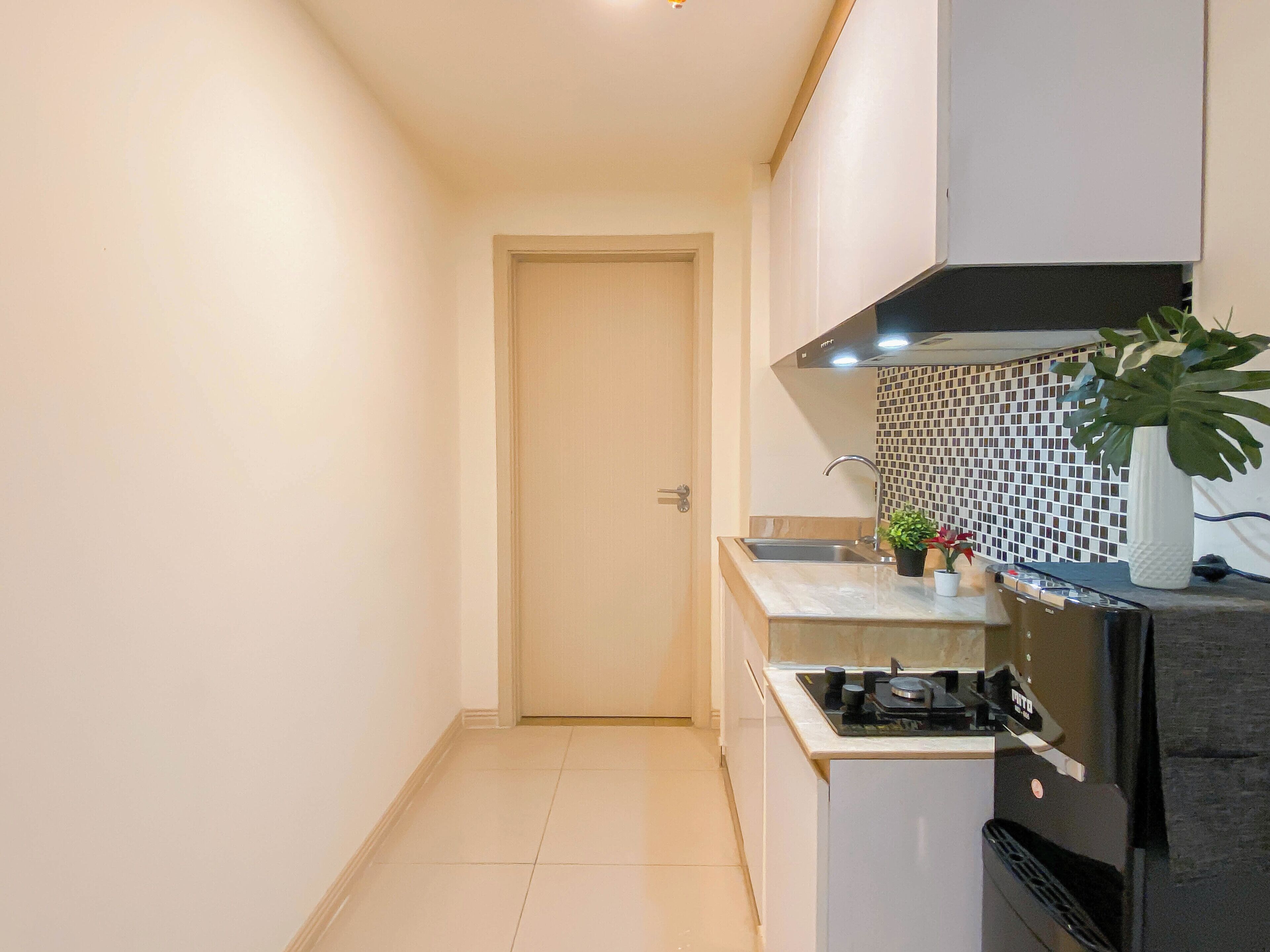 Cocina compacta con estufa a gas, un lavamanos y salpicadero con diseño de mosaico.