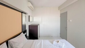 Une chambre d’hôtel avec un lit, un bureau et une armoire.