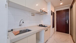 Una cucina moderna con lavello integrato, piano cottura e cappa aspirante.