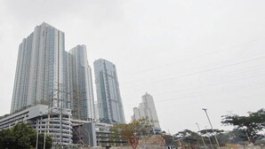 Een stadsgezicht met hoge gebouwen, waaronder een opvallende gebogen constructie en verschillende wolkenkrabbers.