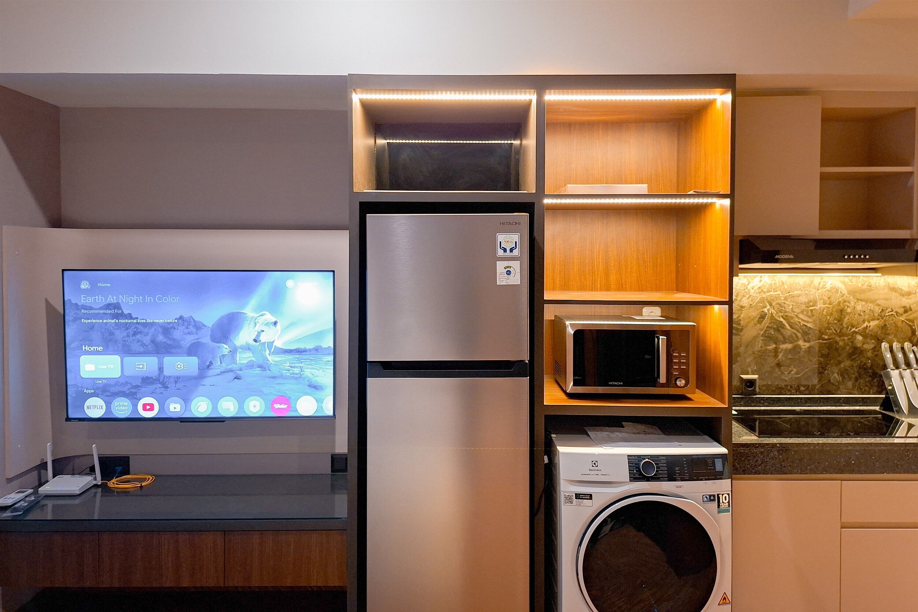 Eine kompakte Küche mit integrierten Geräten, darunter eine Mikrowelle, eine Waschmaschine und ein Kühlschrank.