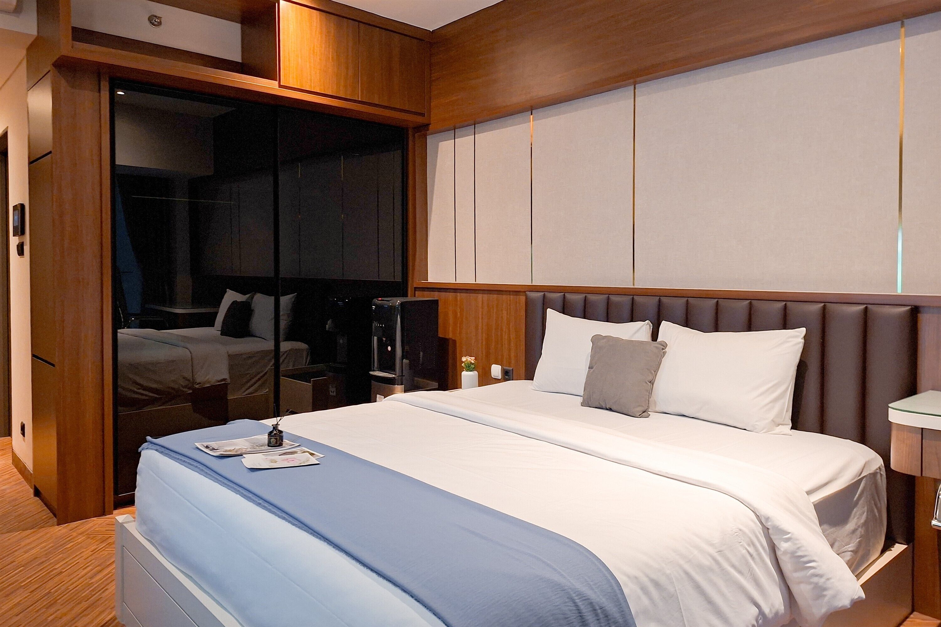 Une chambre d’hôtel avec un grand lit, une armoire, un bureau et un téléviseur.