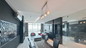 A modern office space with a glass partition, a long table with chairs, and a seating area with sofas. - Spacious And Comfortable Living 3Br Apartment At Aryaduta Residence (Surabaya)
