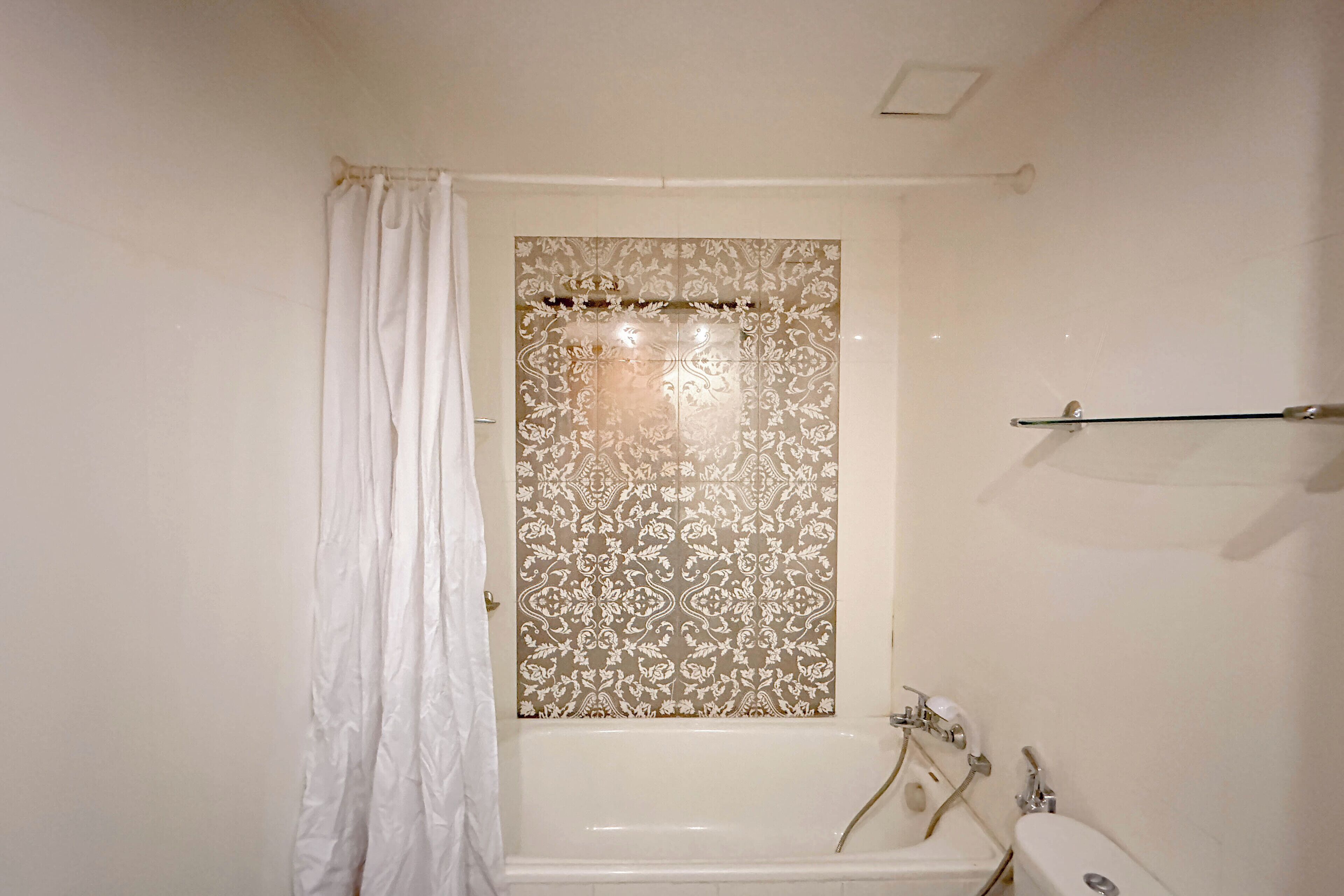 Une salle de bain avec une baignoire, des toilettes et un rideau de douche.