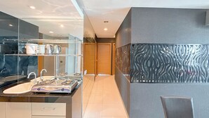 A modern bathroom with a glass enclosure, a sink, and a vanity. - Spacious And Comfortable Living 3Br Apartment At Aryaduta Residence (Surabaya)