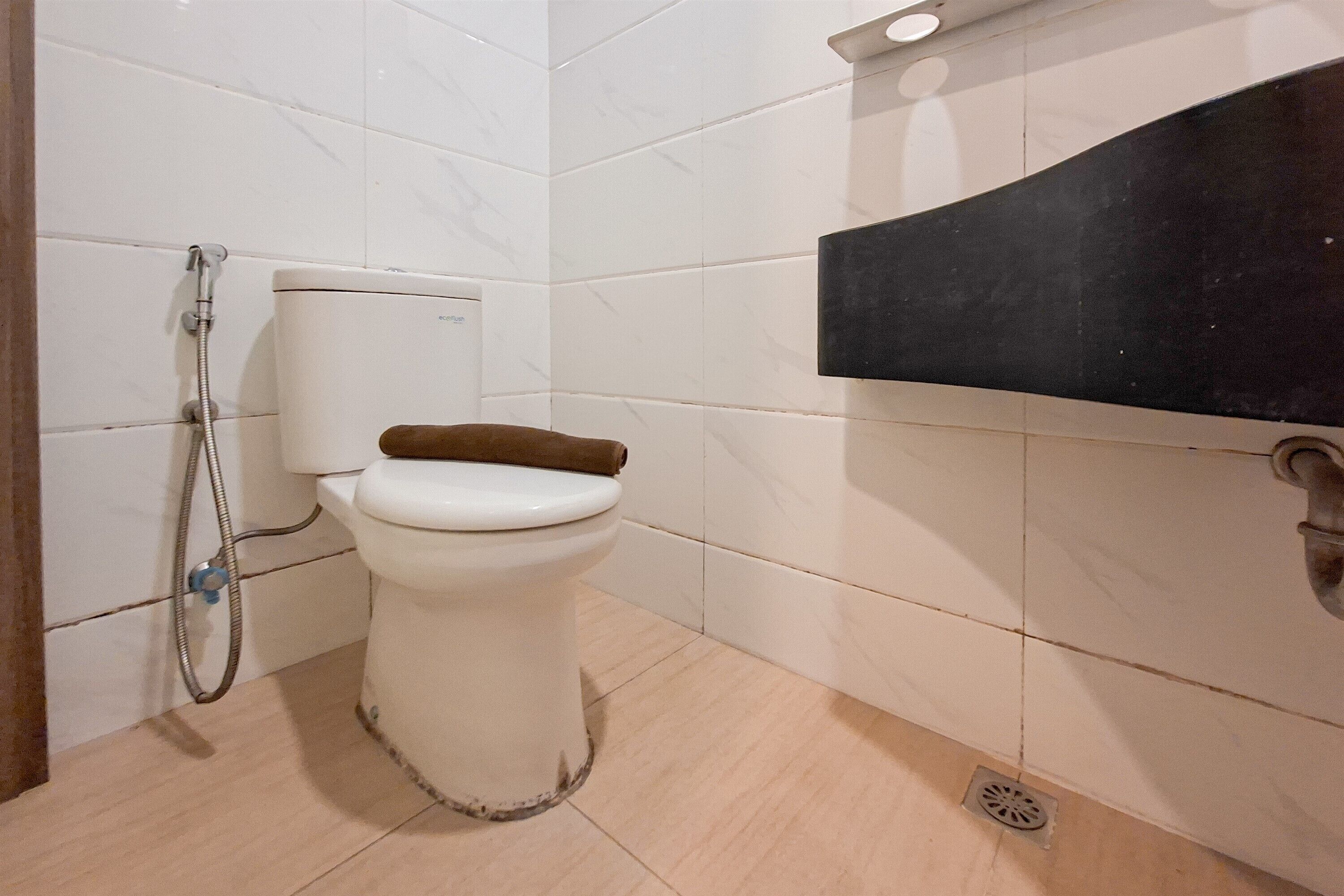 A bathroom with a toilet, a shower, and a sink.