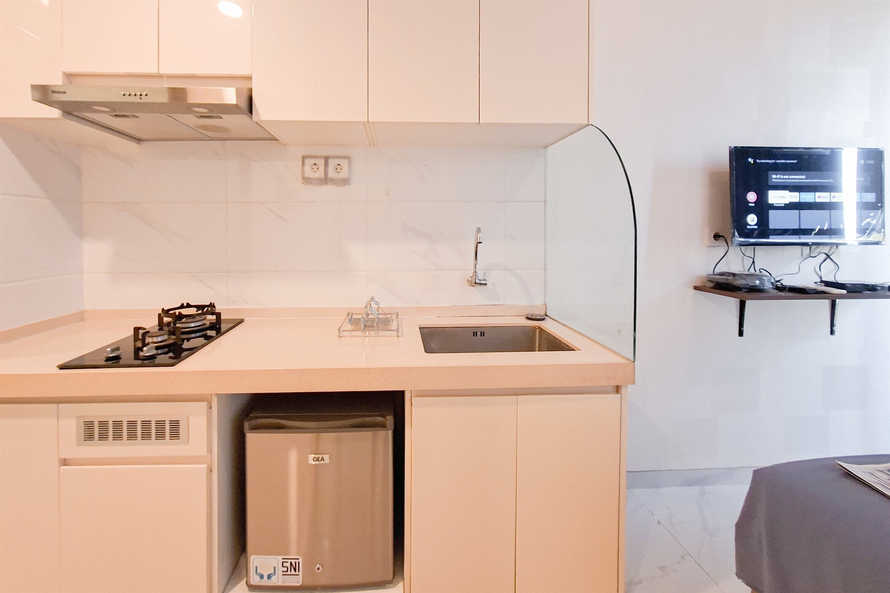 A compact kitchenette with a gas stove, sink, and a small dishwasher.