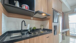 Una cucina moderna con un piano di lavoro nero, mobili in legno, un lavello in acciaio inossidabile e un forno integrato.